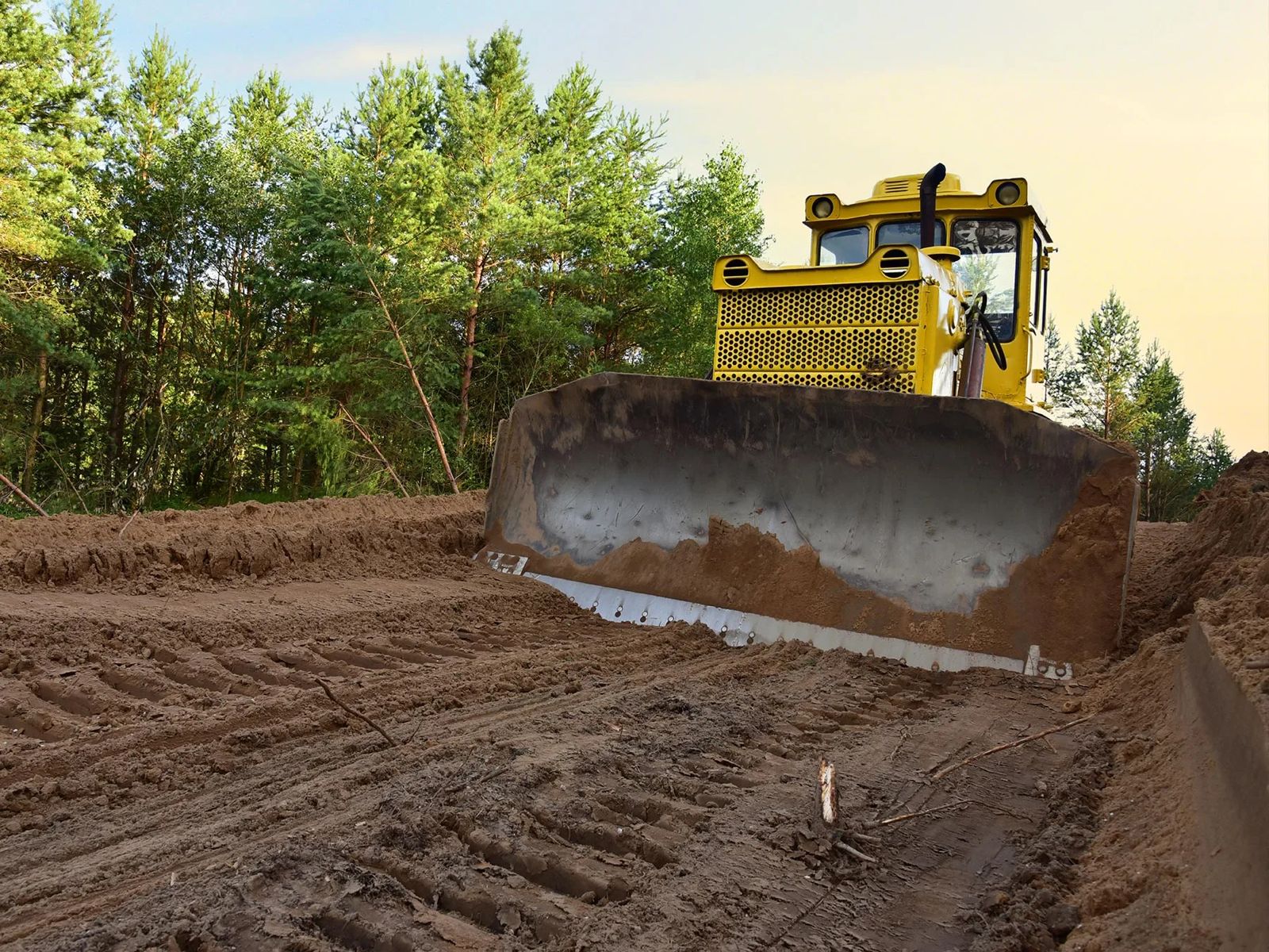 Earthworks and grading with excavator shaping road formation on township site